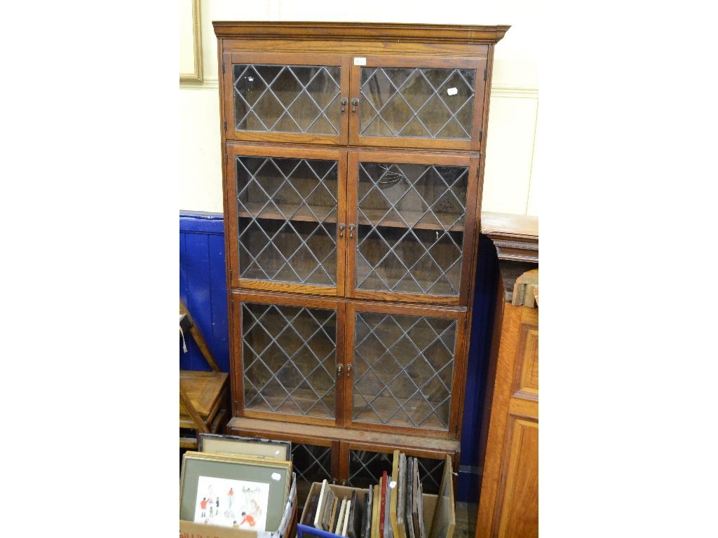 An oak four section Minty style bookcase, with leaded glass doors, 93.5 cm wide