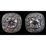 A pair of 18ct white gold and diamond stud earrings, the central brilliant cut stone within a