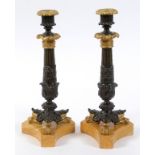 A pair of 18th century style bronze candlesticks, with acanthus leaf decoration, on Sienna marble