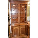 A Victorian mahogany bookcase on cupboard, the moulded and dentil cornice above a pair of bar glazed