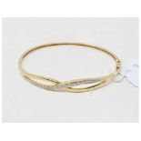 A 9ct gold crossover style bangle, set diamonds, approx. 7.3 g (all in)