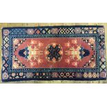 A Chinese rug, decorated flowers on a pink ground, within a multi border, 63 x 117 cm Report by GH A