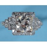 An Art Deco style platinum and diamond ring, the central old brilliant cut stone in a stepped square