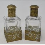 A pair of glass scent bottles, with metal mounts having Rococo type decoration, 16 cm high (2)
