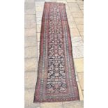 A Persian Malayer runner, with floral motifs on a blue ground, within a multi border, 450 x 90 cm