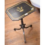 An ebonised tripod occasional table, the top decorated a fleur de lys, on scroll supports, 39 cm