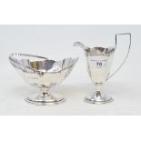 A George III style silver cream jug, 14 cm high, with a matching swing handle sugar bowl, Birmingham