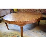 A low table, inlaid with a sunburst style geometric design, on tapering legs, 104 cm diameter