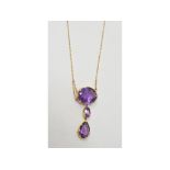 A three stone amethyst pendant, on a yellow metal chain, with an amethyst set clasp Report by NG