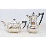 A silver teapot and cover, Sheffield 1963, 15.5 cm high, and a matching hot water jug, 23 cm high,