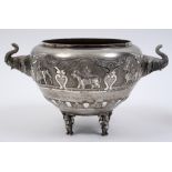 An Indian silver coloured metal bowl, with presentation inscription, embossed deities and animals,