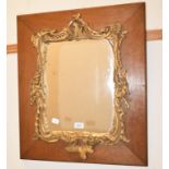 A rococo style carved giltwood wall mirror, on a hardwood mount, 54 cm wide