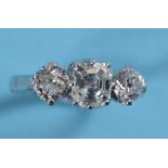 A three stone diamond ring, the central ascher cut diamond flanked by two brilliant cut stones, in a