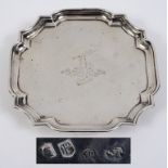 An early 18th century silver salver, crested, of shaped square form, on four pad feet, John Tuite,