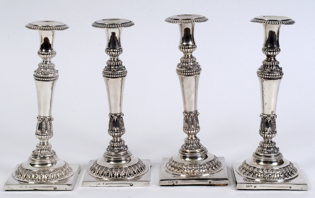 A set of four 19th century German silver coloured metal candlesticks, with acanthus leaf decoration,