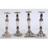 A set of four 19th century German silver coloured metal candlesticks, with acanthus leaf decoration,