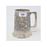 An Indian silver coloured metal tankard, embossed elephants, figures and landscapes, 13 cm high