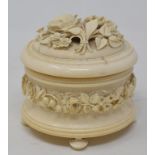 A late 19th/early 20th century ivory oval casket, deeply carved flowers and foliage, on turned feet,