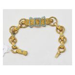 A 19th century gilt metal bracelet, with central bow and buckle section inset turquoise, and each