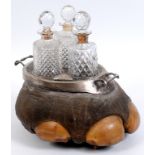 An Edwardian silver mounted elephants foot three bottle tantalus, with two built in snuff boxes, a