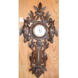 A Black Forest carved walnut barometer, decorated hanging game and foliage, 30 cm wide