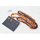 A garnet bead necklace, with a 9ct gold clasp, an amber type bead necklace, and two pairs of 9ct