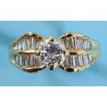 An 18ct gold and diamond ring, the central brilliant cut stone flanked by baguette cut stones,