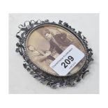 A late 19th century silver coloured metal oval photograph frame, decorated foliage, slight loss,