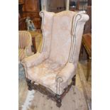 A large colonial wing back armchair, on turned and carved legs and stretchers
