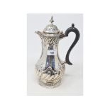 A late Victorian silver hot water jug, of baluster form, with embossed decoration, Sheffield 1895,