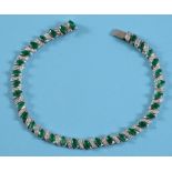 An emerald and diamond line bracelet, set marquise emerald and brilliant cut diamonds, in a white