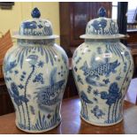 A pair of Chinese pottery vases and covers, decorated fish and foliage, 53 cm high (2) Modern