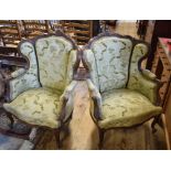 A pair of French walnut armchairs, with upholstered backs, carved flowers and foliage, on cabriole