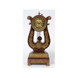 A French Empire style lyre clock, the 8 cm diameter brass dial with Roman numerals, in a mahogany