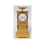 A 19th century French mantel clock, the 8 cm diameter enamel dial with Roman numerals, in an