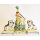 A Staffordshire pottery pheasant, 25.5 cm high, and a pair of Staffordshire pottery spaniels, on