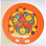 A Poole Pottery Delphis charger, 35 cm diameter, a similar vase, 11 cm high, a pin tray and