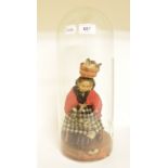 A wax doll, on a wooden plinth, 24 cm high, under a glass dome, dome broken See inside front cover