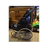 A late Victorian/early Edwardian doll's type pushchair, with black painted coachwork, 81.5 cm high