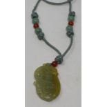 A Chinese carved and pierced jade pendant, in the form of a mythical animal on a fruit, the