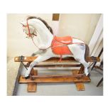 A carved and painted wood safety type dapple grey rocking horse, with red leather reins and