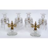 A pair of Regency style gilt metal and cut glass two light candelabra, with prismatic drops, one