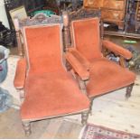 A pair of Victorian oak library chairs, the crest rails carved lion face masks and scrolling foliage