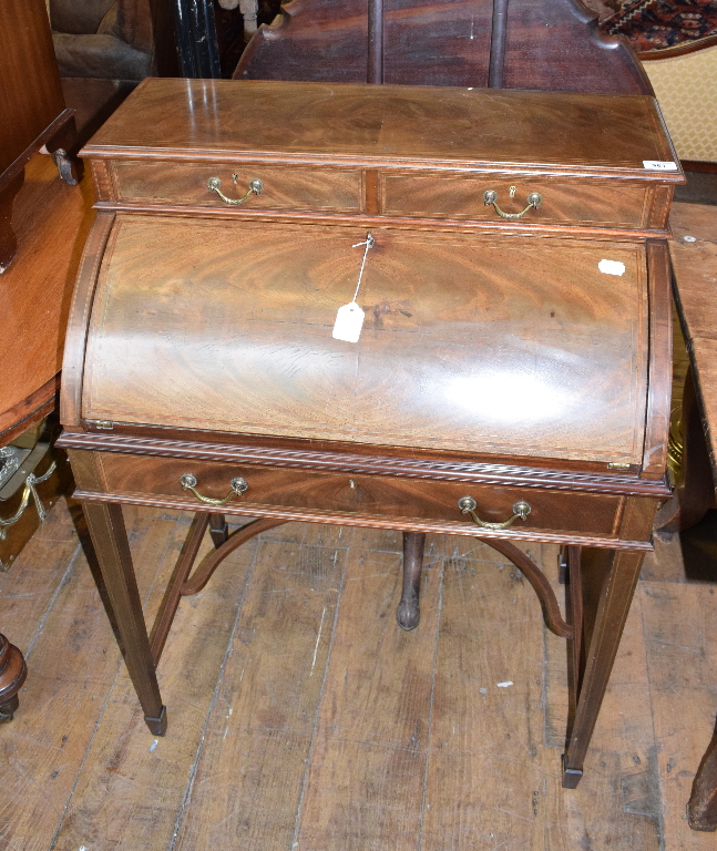 An Edwardian inlaid mahogany cylinder desk, on tapering square legs joined by a shaped undertier, 75