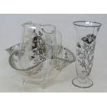 A glass vase, with silver coloured metal overlay floral decoration, 24.5 cm high, a matching jug and