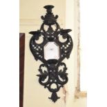 A pair of late 19th century wall mirrors, in carved wood ebonised frames, decorated shells and