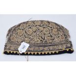 An Indian velvet cap, with gold thread decoration applied gems, 27.5 cm wide