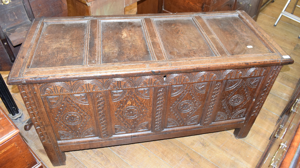 An oak coffer, with carved decoration, on stile legs, 143 cm wide