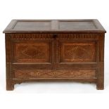 An 18th century inlaid and carved oak mule chest, on stile legs, 119 cm wide See illustration