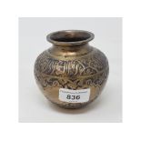 An Islamic brass vessel, of compressed baluster form, decorated foliage and calligraphy, 9 cm high